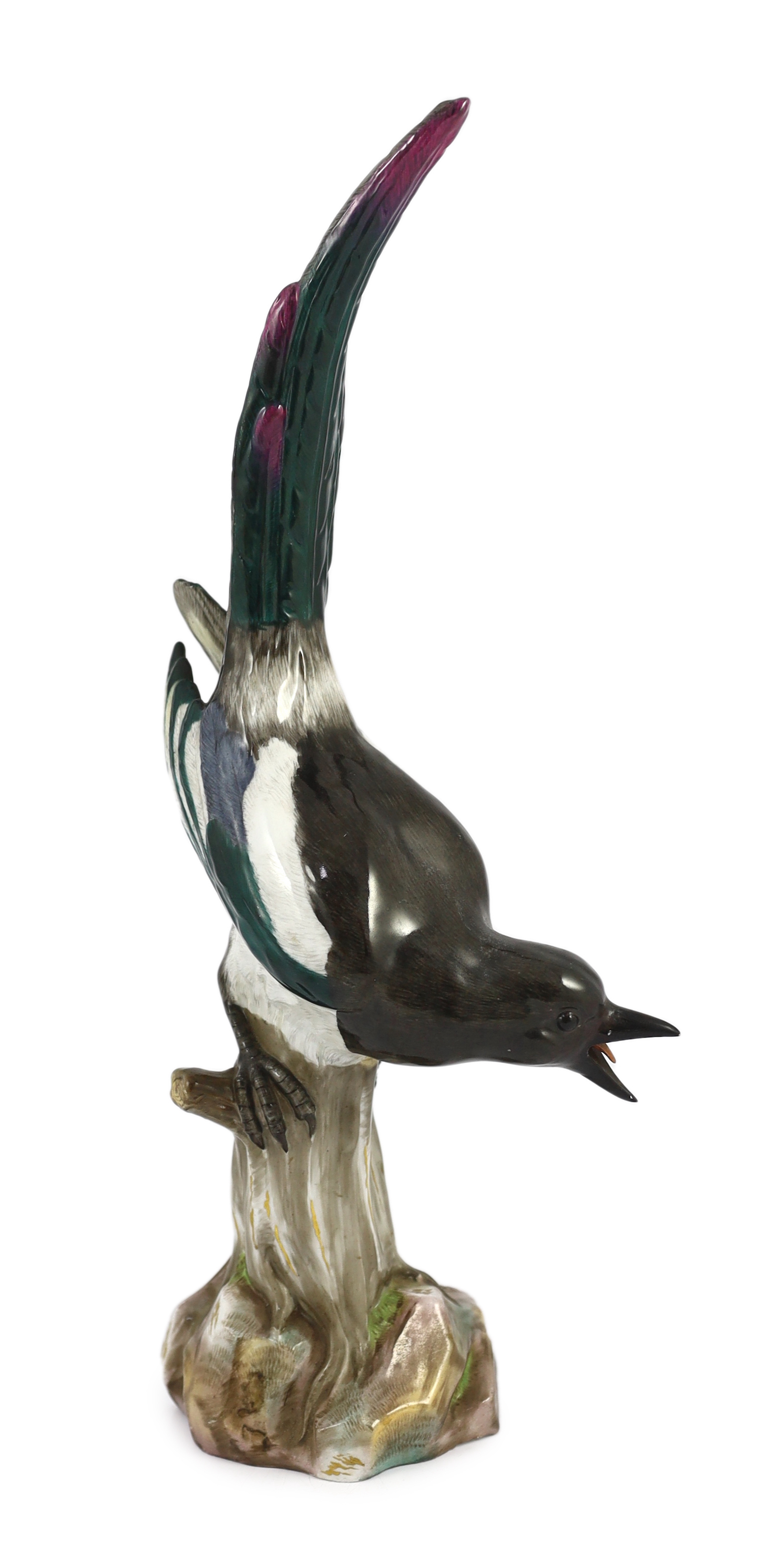 A tall Meissen figure of a magpie, 19th century, perched on a tree stump, incised model no. 62, underglaze blue crossed swords mark, 50cm high, restoration to beak and one wing tip